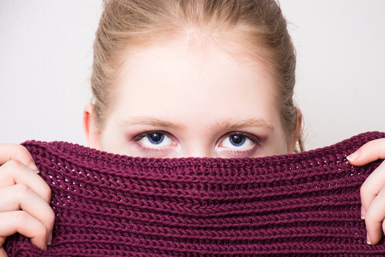 Woman hiding behind scarf